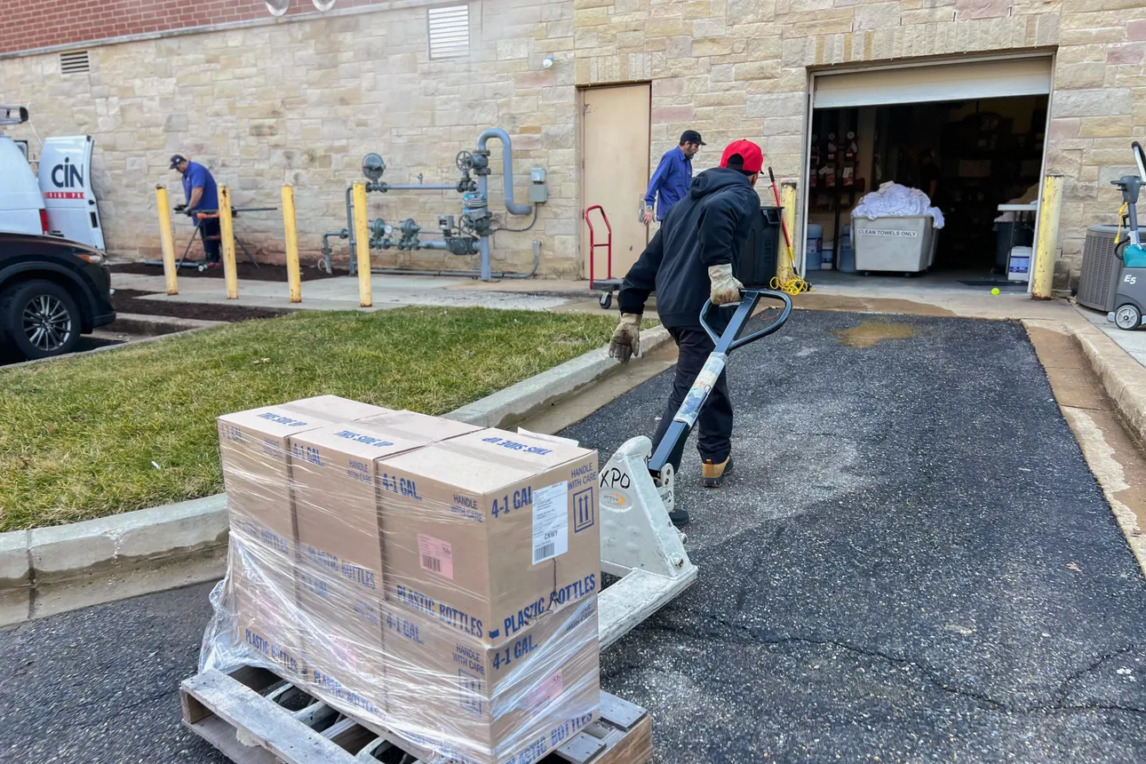 XPO driver Steadman Mitchell pulls the pallet of plastic bottles to the fitness club’s rear service entrance.