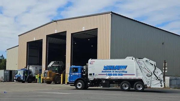 A truck with the logo "G.W. Shaw & Son Rubbish & Recycling" sits in front of an industrial building in Greenville, New Hampshire