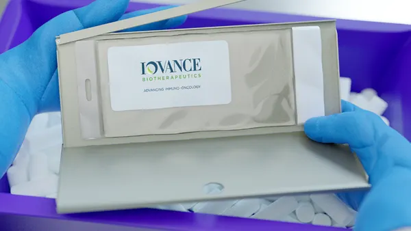 Packaging for Iovance Biotherapeutics' cellular medicine Amtagvi is held by a technician wearing gloves.