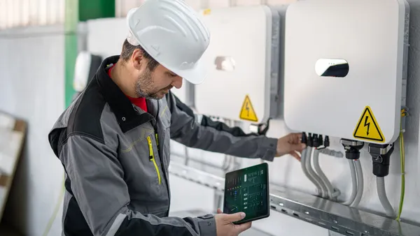 A technician services a smart grid electrical system.