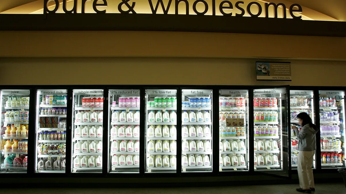 A customer stands in front of the milk aisle