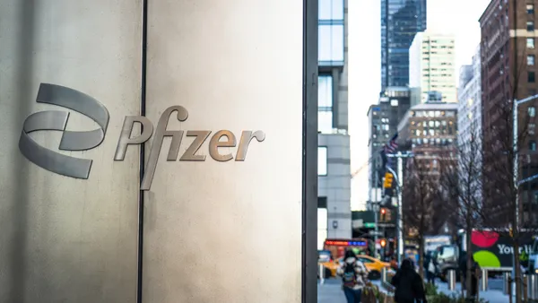 People pass an office building with signage spelling Pfizer in New York City.