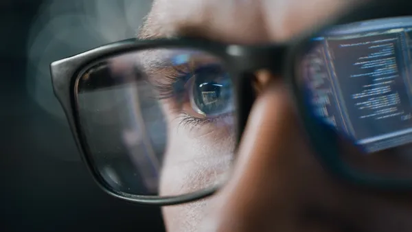 Close-up Portrait of Software Engineer Working on Computer, Line of Code Reflecting in Glasses.