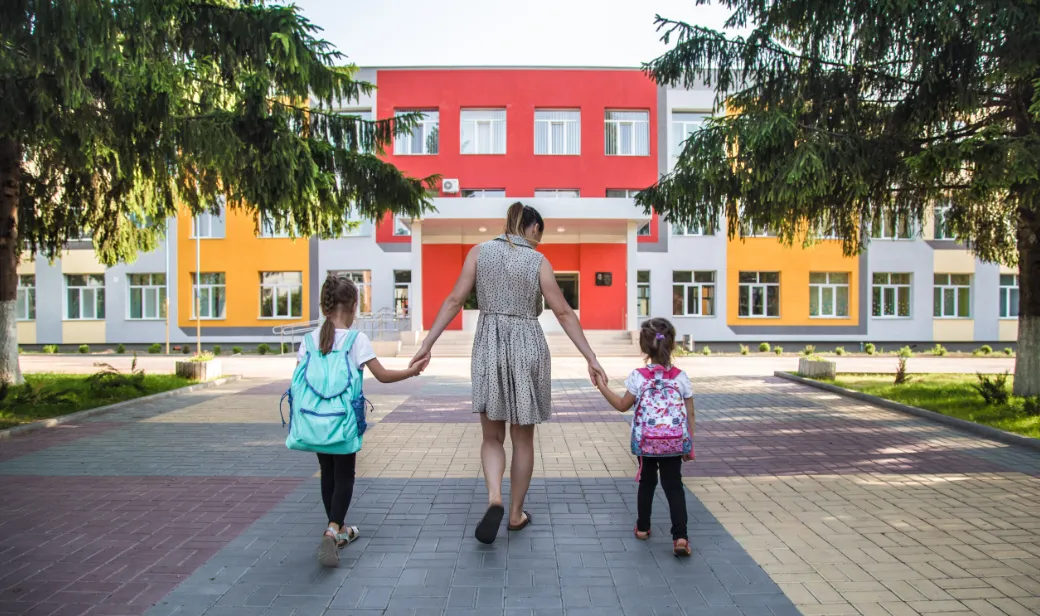 Parent walking with children towards school