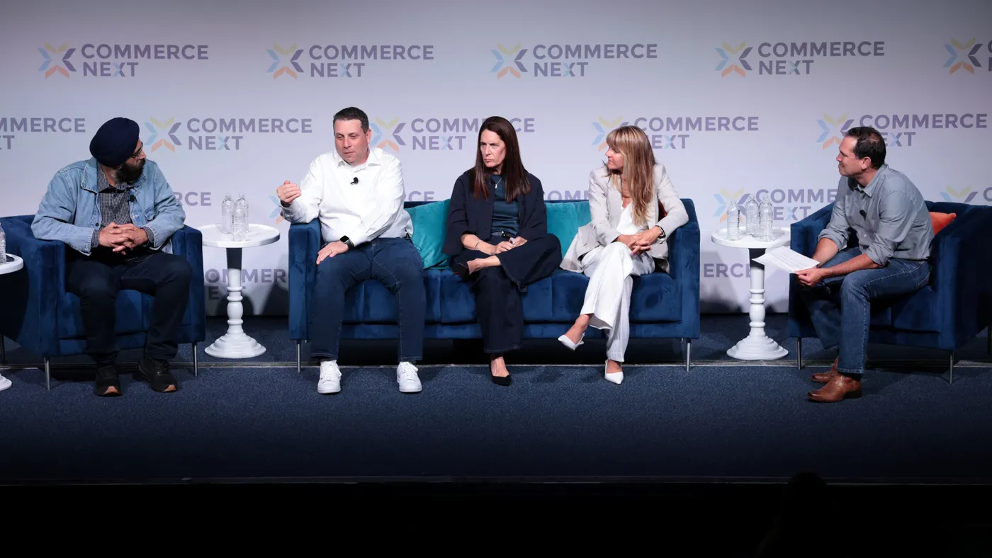 A group of panelists seated on a stage, actively in discussion.