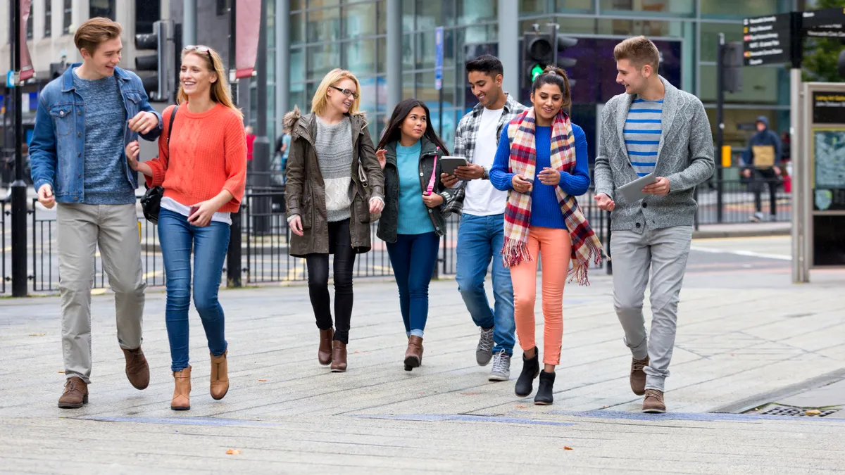 A group of students walking on a college campus.