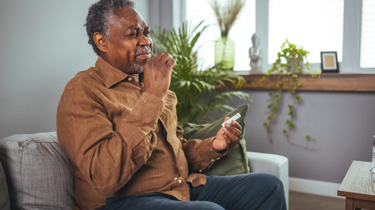 An elderly man gives himself a covid test