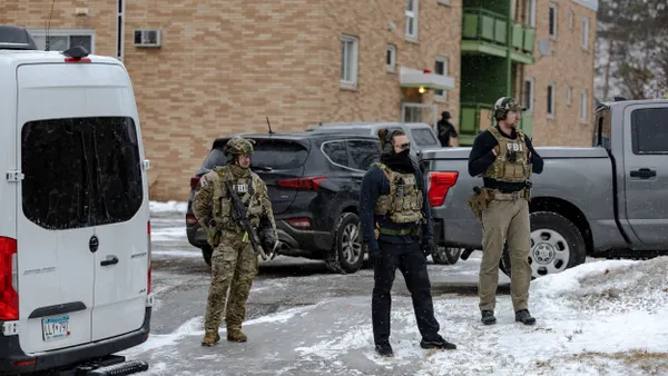 Federal agents stand guard outside an apartment building