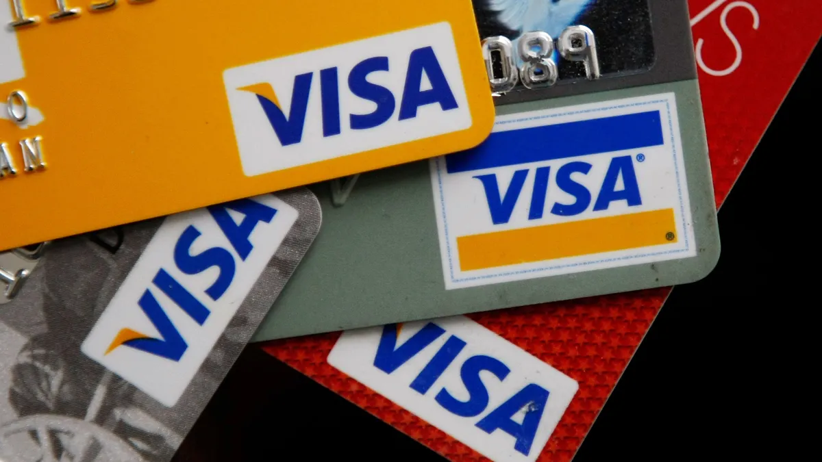 Several Visa cards spread out on surface revealing company's logo.