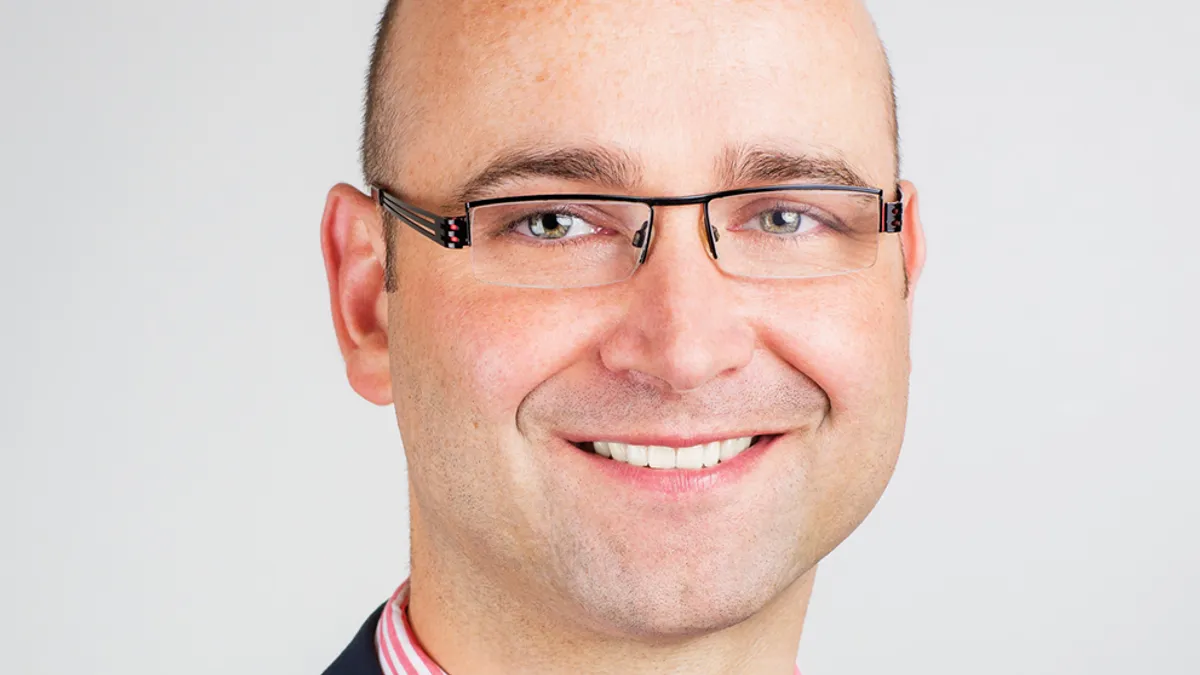 An image of Abbott's electrophysiology chief medical officer Christopher Piorkowski, who is smiling and wearing a suit and tie.