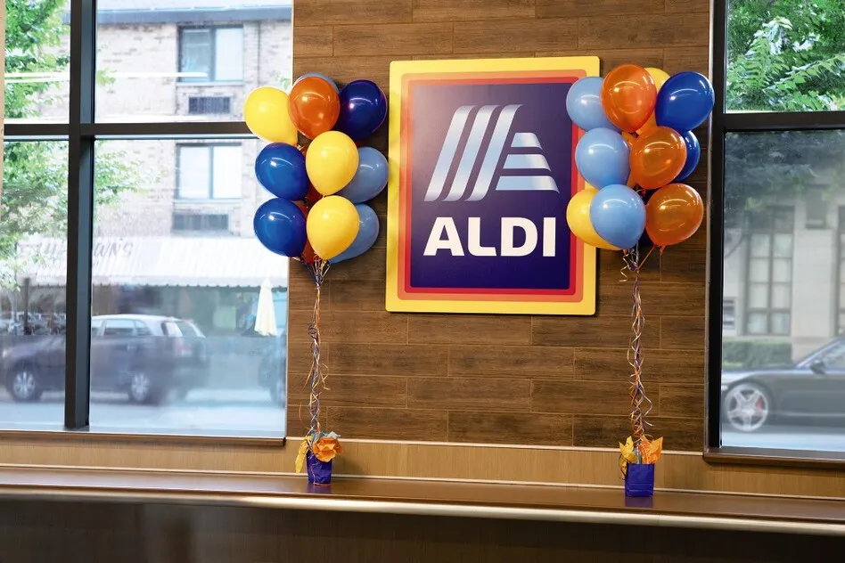 An Aldi sign inside a store flanked by multicolor balloons.