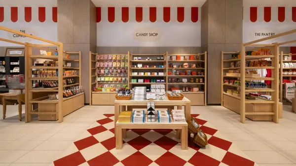 A series of wood shelves stocked with food items at a Nordstrom store.