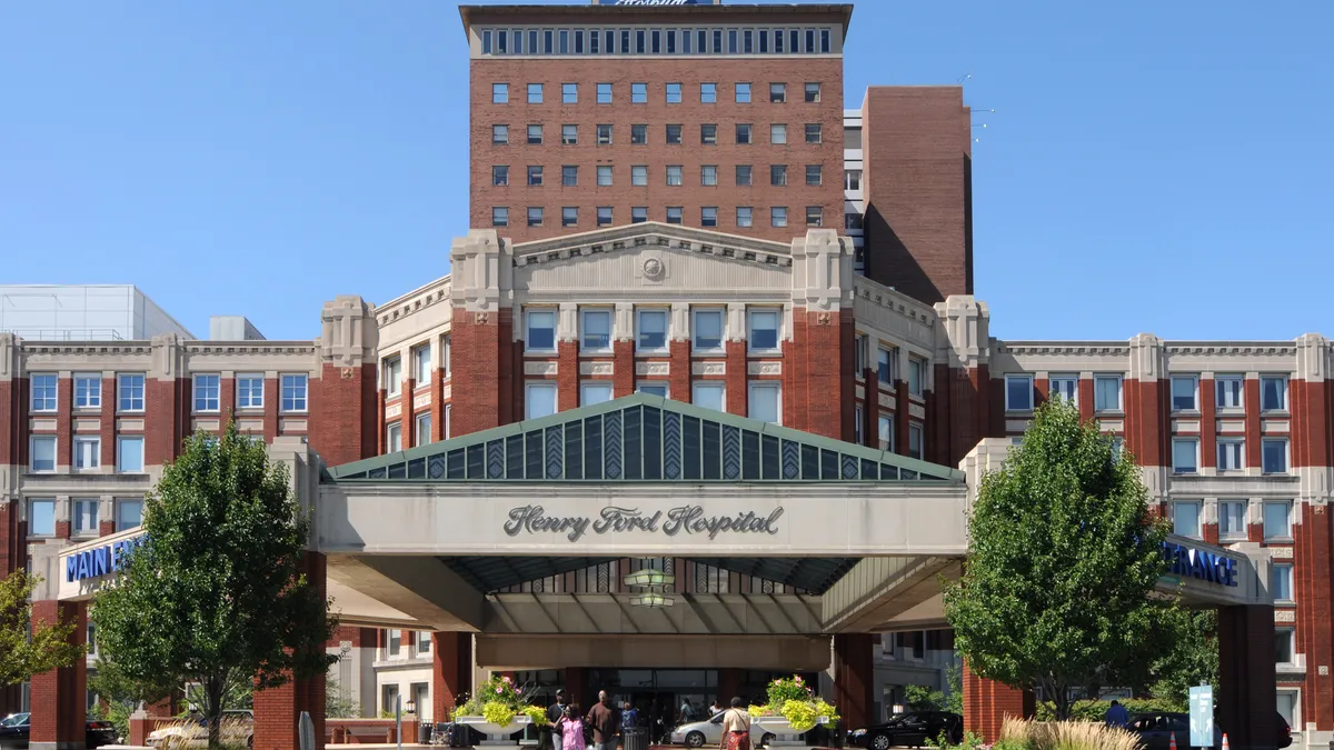 Front entrance of a Henry Ford Hospital with a blue sky in the background.