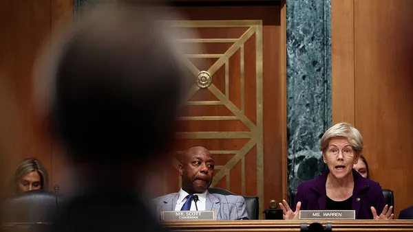 Sen. Elizabeth Warren and Sen. Tim Scott sit in a hearing.