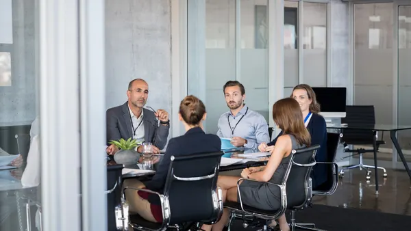Business people sitting in boardroom and working together at new strategy plan.