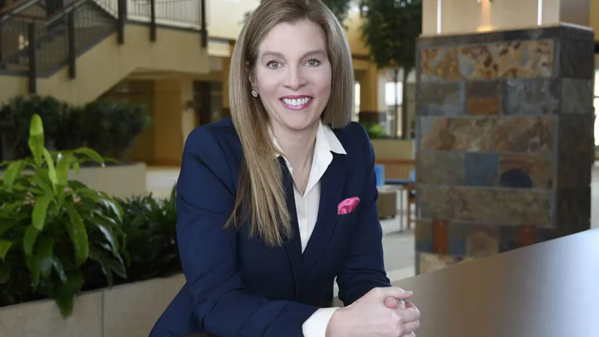 Professional photo of Karen Parkhill standing indoors in front of a pillar and stairs.