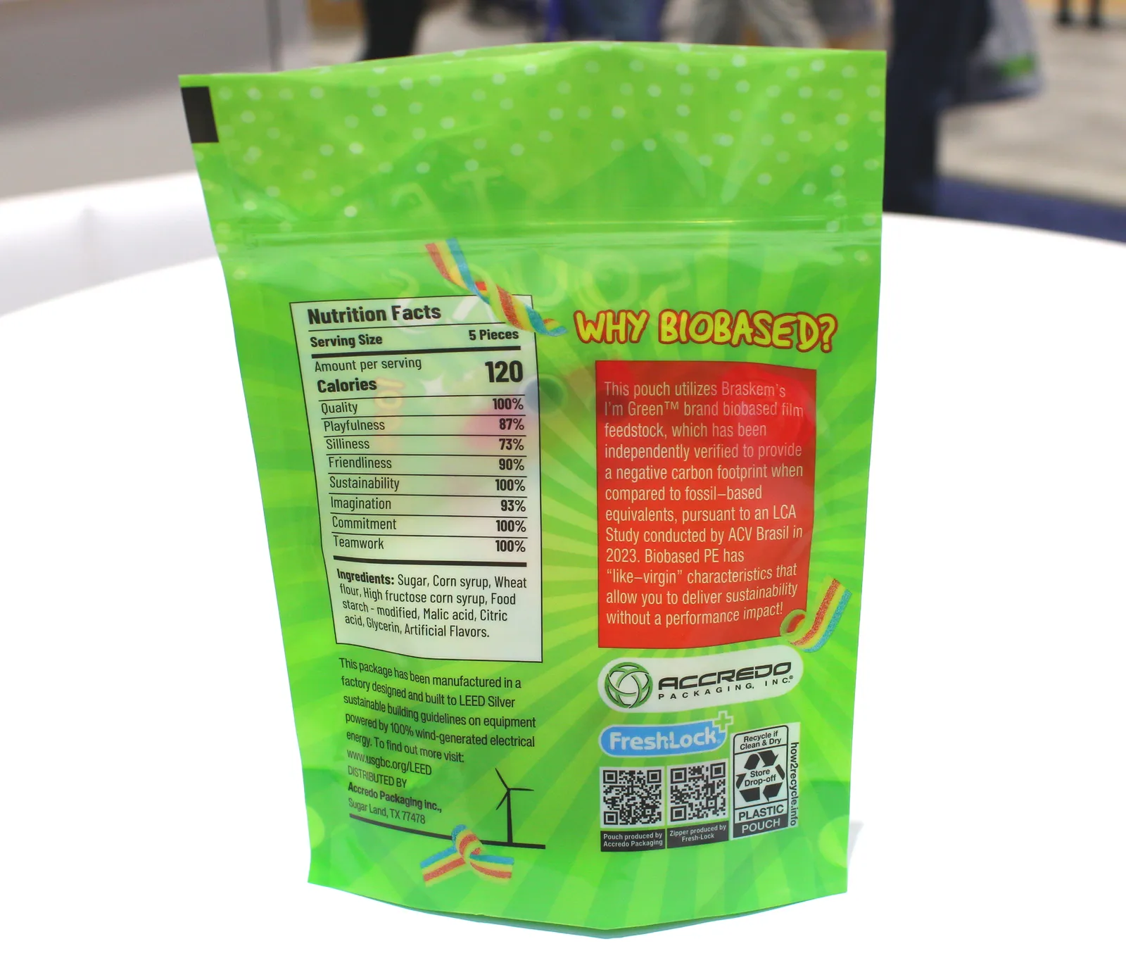 The exterior of a bright green plastic pouch bears messaging that says &quot;biobased&quot; and a label describing how to recycle it.