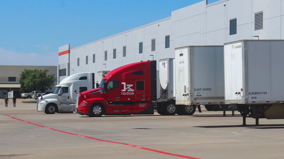 A red Kodiak truck is parked next to other tractor-trailers at an office park where the company's Lancaster terminal is.