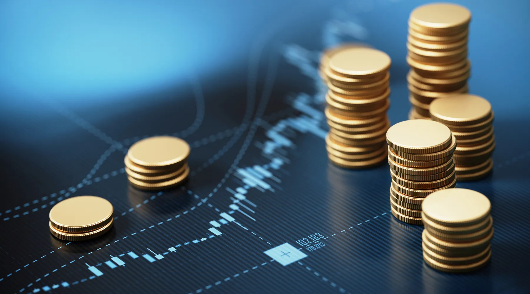 Coin stacks sitting on blue financial graph background. Horizontal composition with selective focus and copy space.