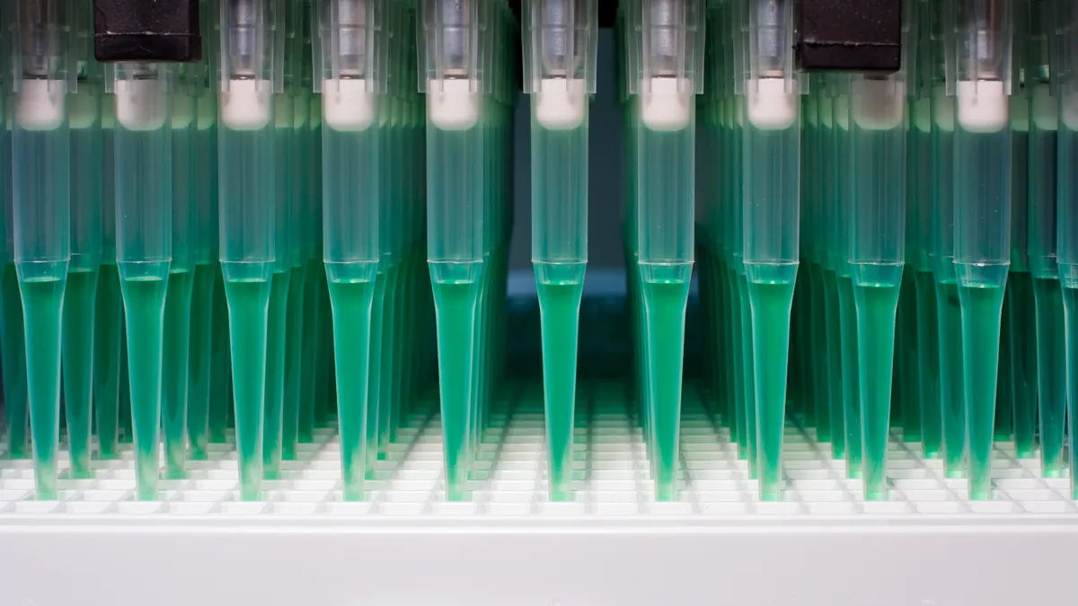 A stock image of robotic dispersion of fluid into a well plate.