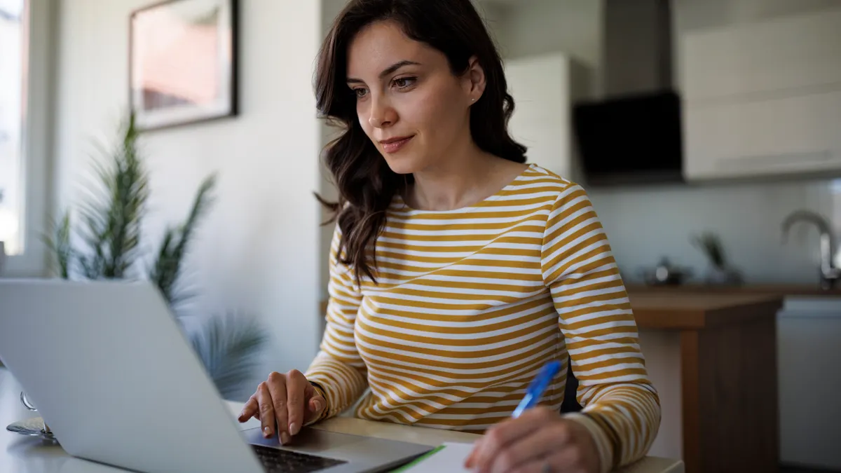 woman on her laptop taking notes
