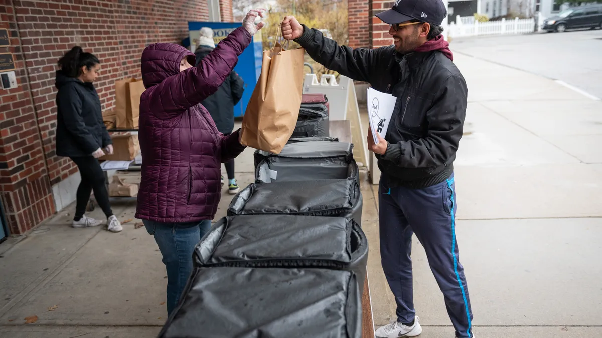 A parent picks up school meals in Boston at New Mission High School