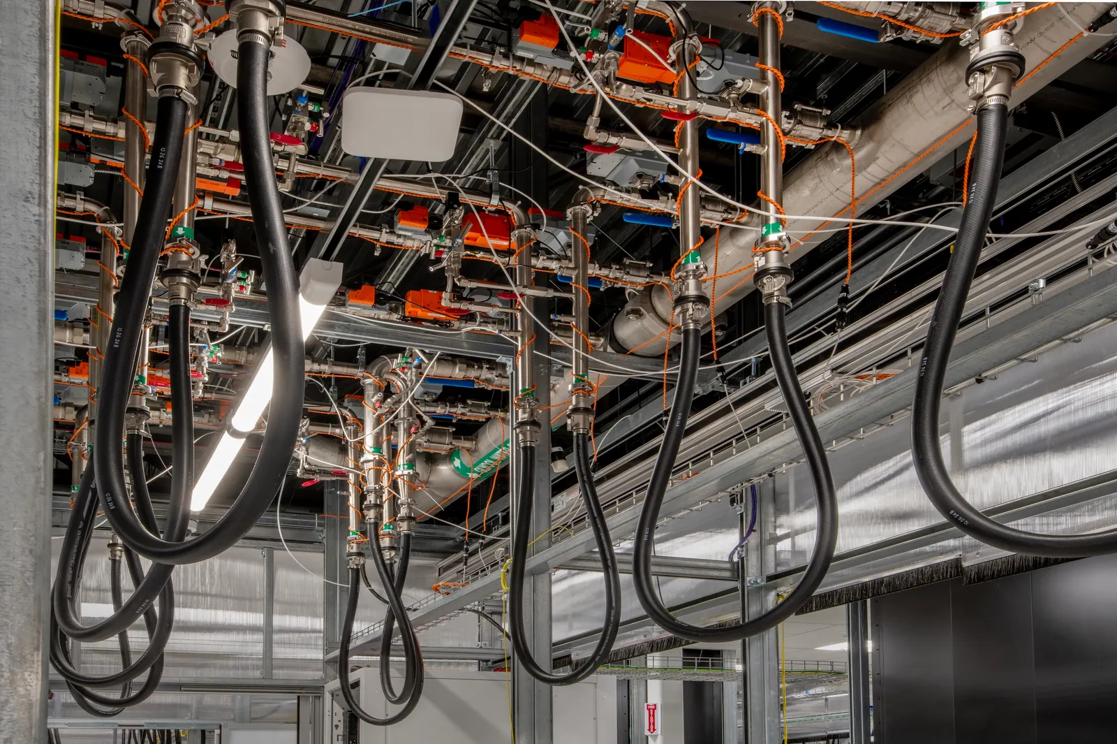 Hoses and cooling equipment hang from the ceiling of a data center