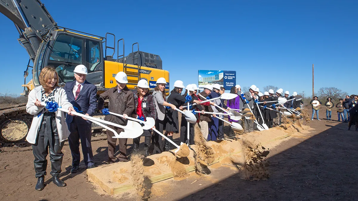 An image shows executives shoveling dirt at a ground breaking ceremony.