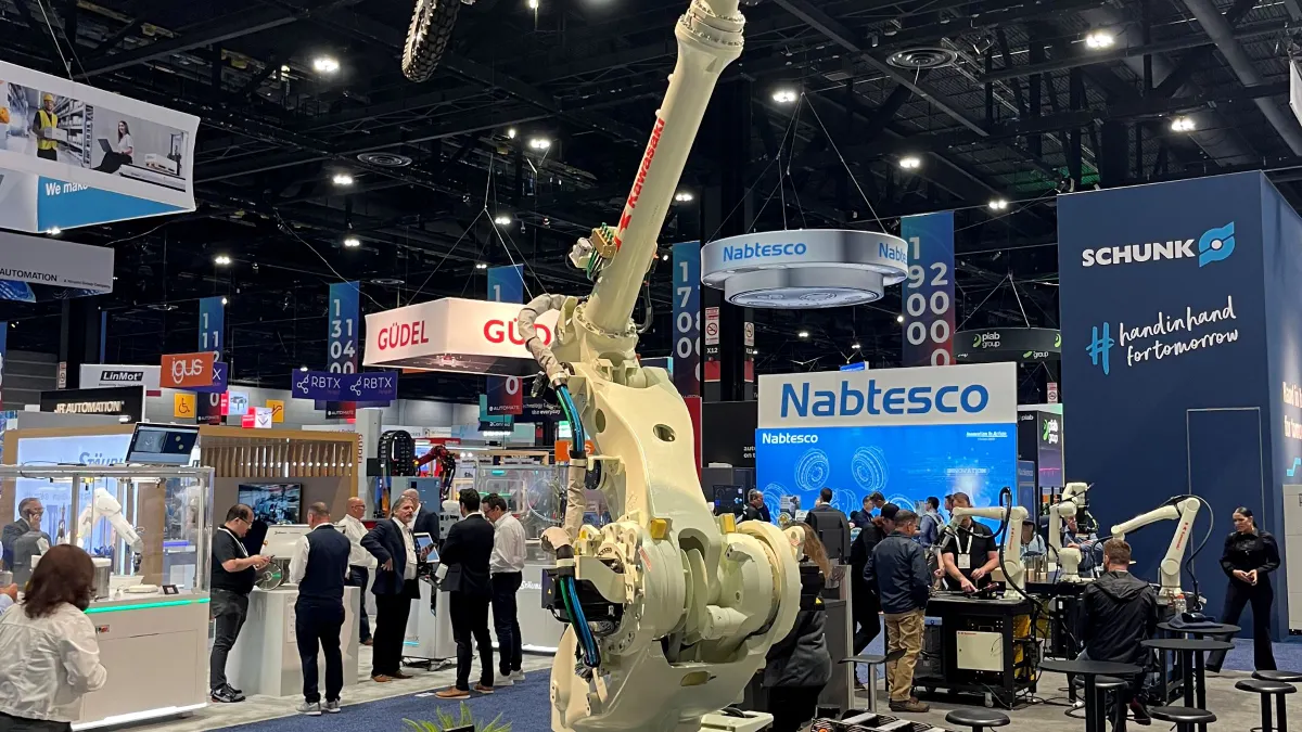 Kawasaki displays a heavy-duty industrial robotic arm carrying an off-road motorcycle at Automate 2026 in Chicago.