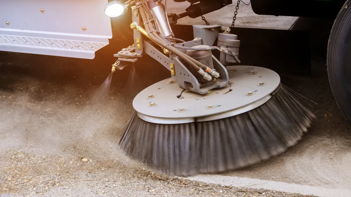 Active street sweeper on road.