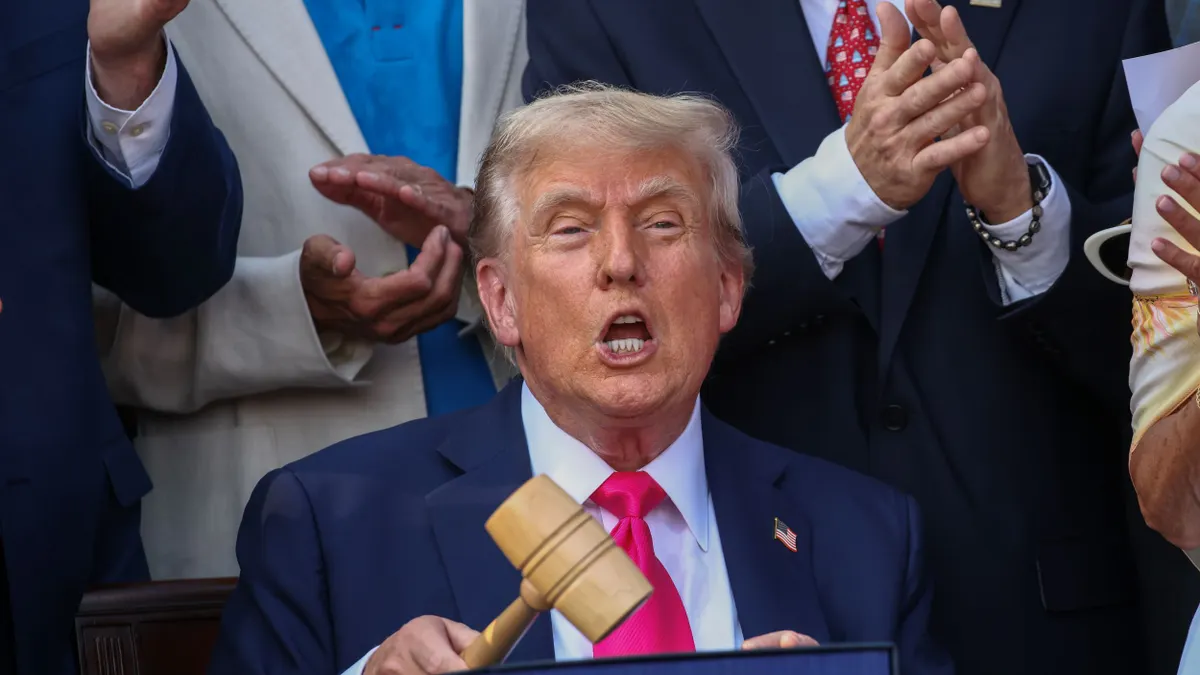 Donald Trump, holding a gavel, celebrates his signing of the One Big Beautiful Bill Act.