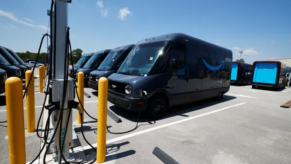A fleet of electric delivery vehicles connected to chargers