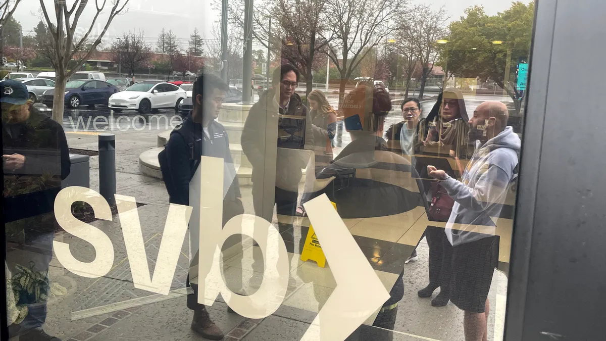 A crowd of people stands outside Silicon Valley Bank headquarters.