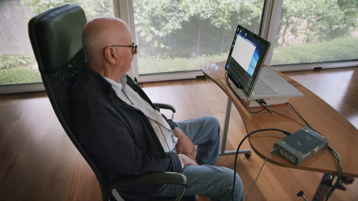 Graham Felstead sits in front of a computer screen.