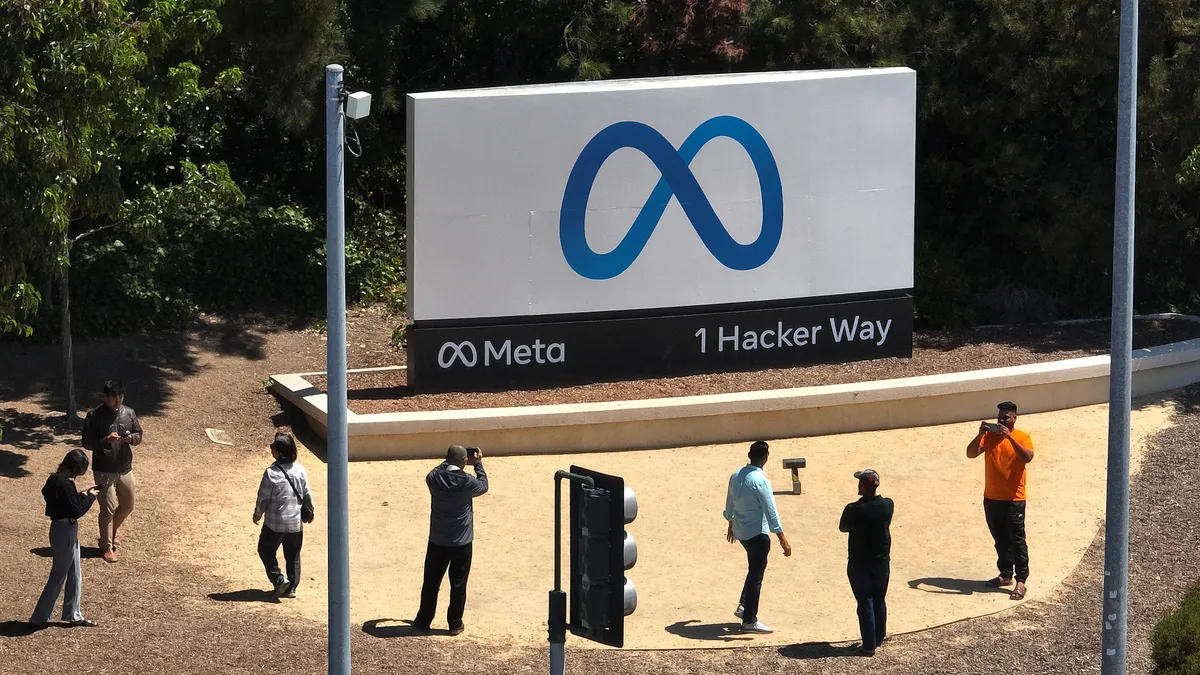 In an aerial view, people gather in front of a sign posted at Meta headquarters on July 07, 2023 in Menlo Park, California.