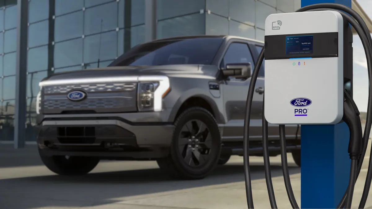 A Ford truck parked in front of an electric vehicle charger branded "Ford Pro."