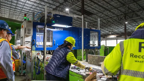 workers pull material off a conveyor at a recycling facility