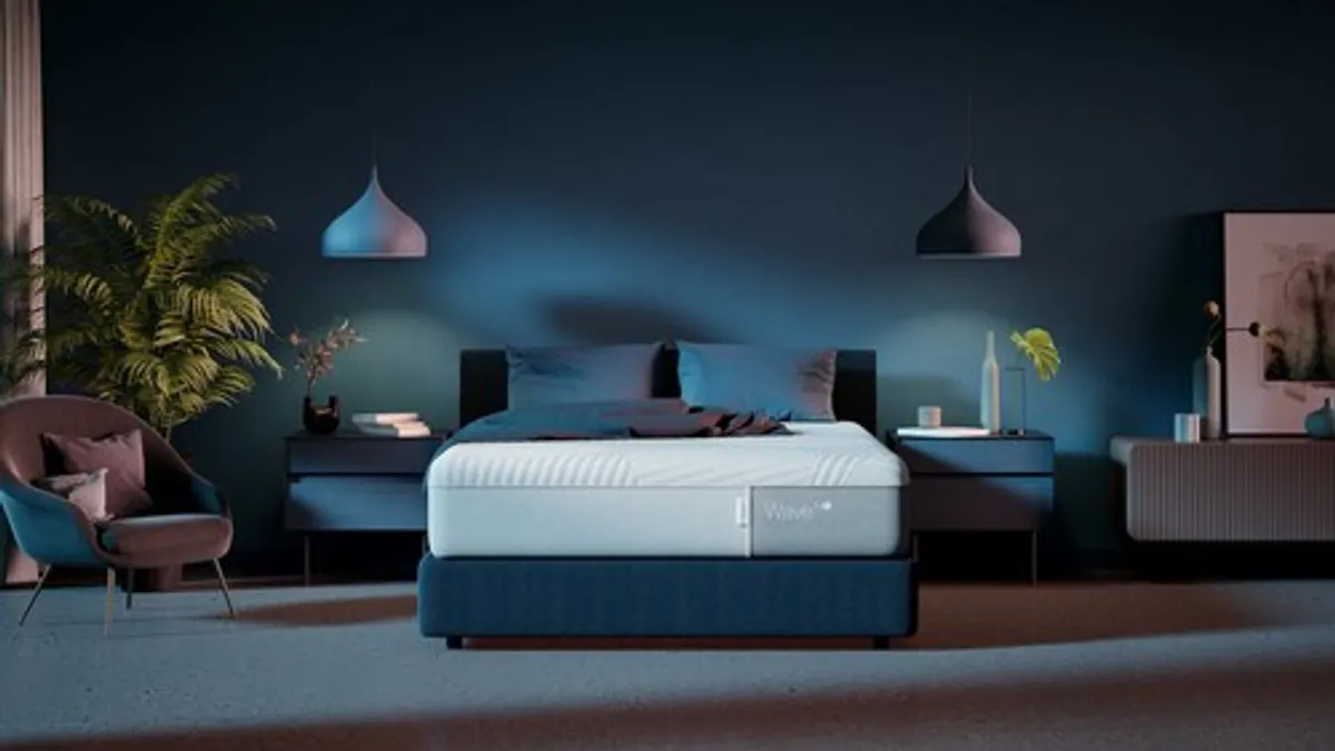 A white bed in a moody, dark blue room.