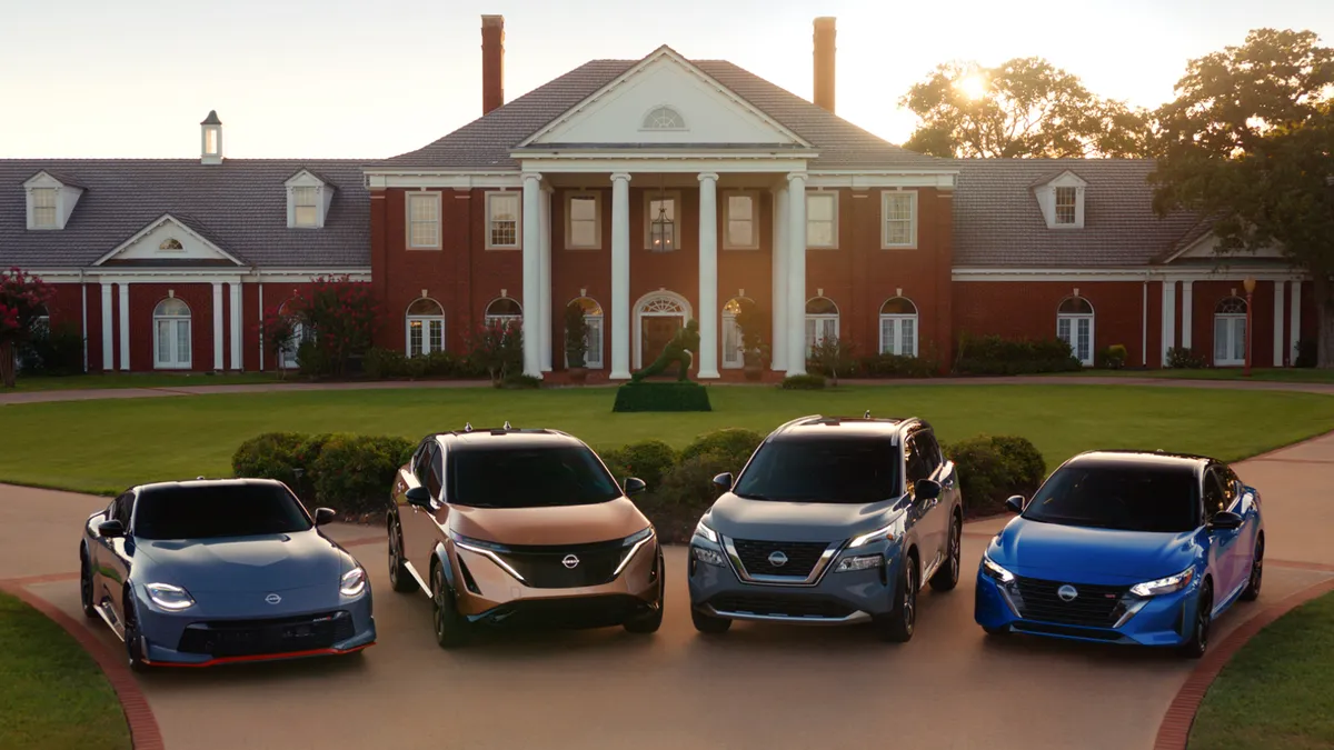 A row of Nissan vehicles in front of a mansion promote the automaker's Heisman House campaign.