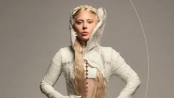 Lady Gaga wearing a white gown appears in a promotional image for Mastercard to promote her album "Mayhem."