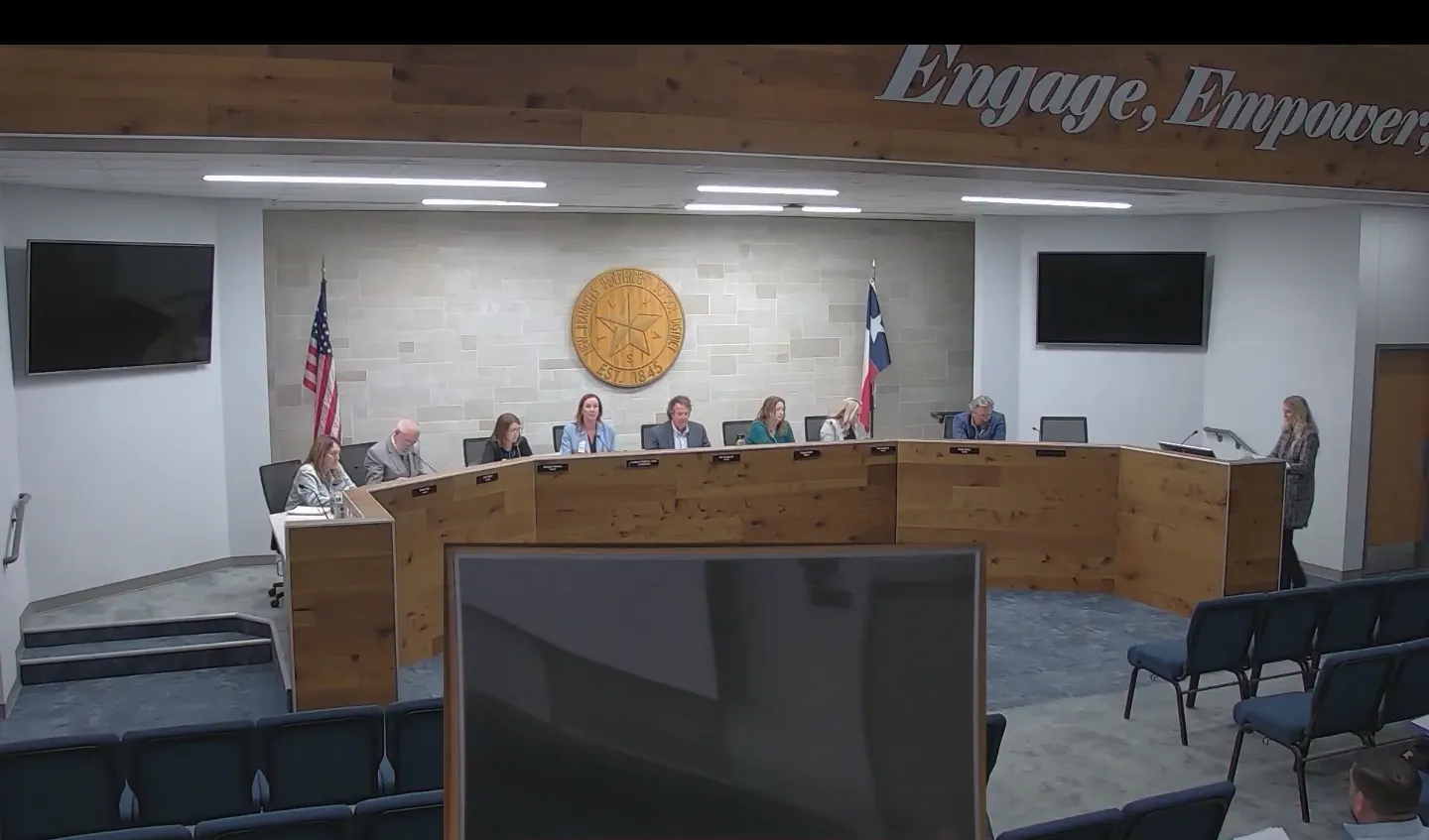 Board members sit behind a desk