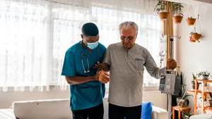 A man being helped by a home health care aide