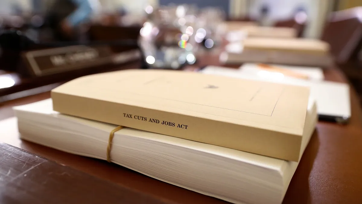 A printed copy of the 2017 Tax Cut and Jobs Act is seen lying on a desk with other papers.