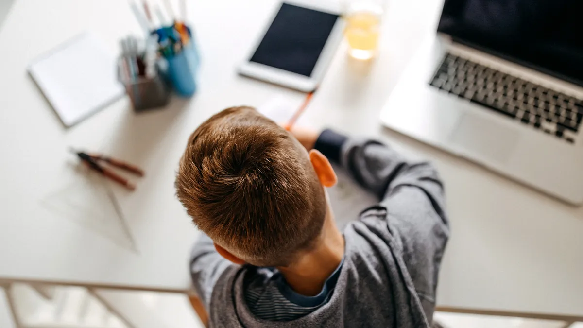 Young boy sitting in his room and doing homework