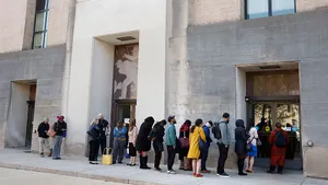 A line of people stand outside the Switzer Memorial Building in Washington, D.C.