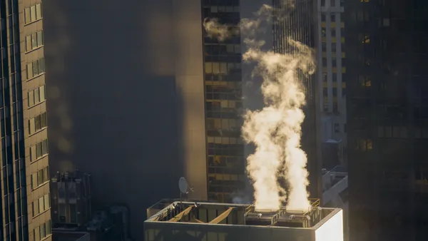 White smoke comes rolling out of the vents in a building.