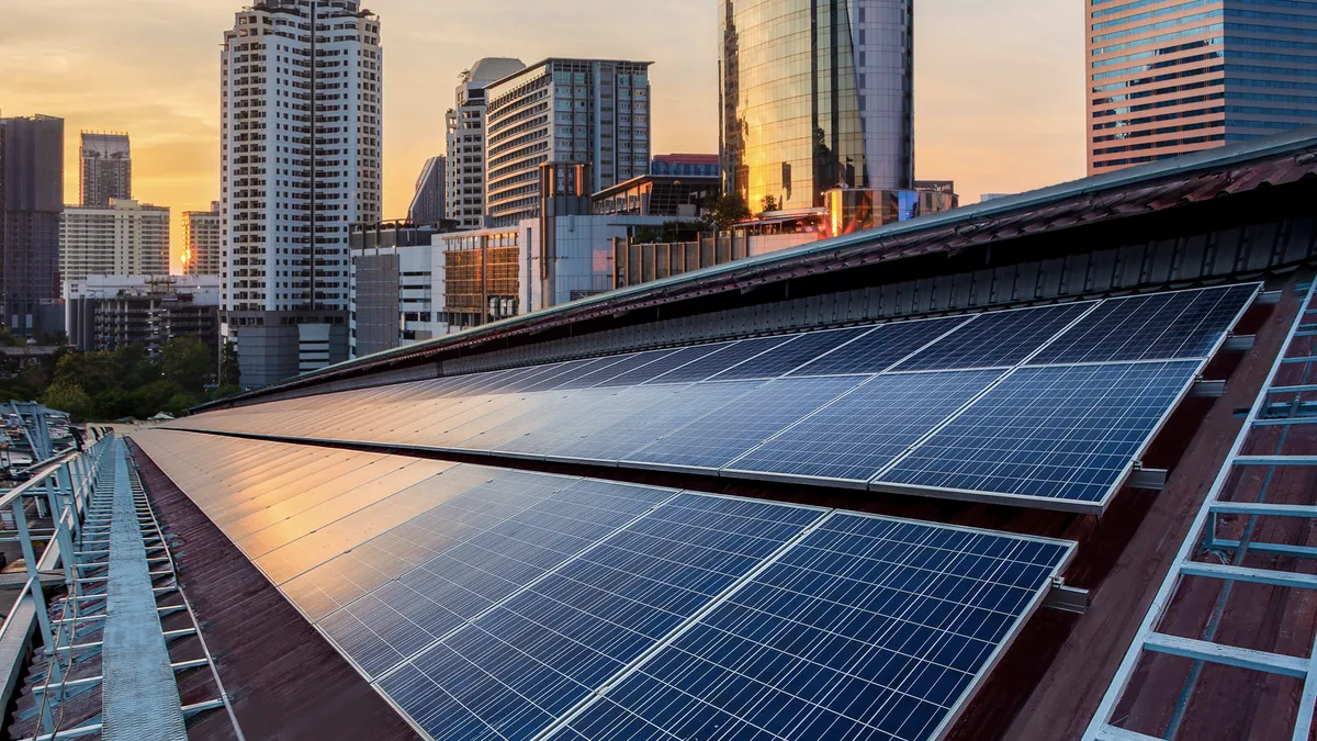 A solar panel rooftop photovoltaic installation with a city skyline in the background.