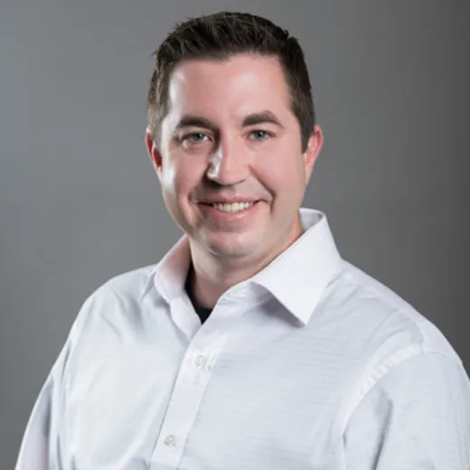 A headshot of a man with brown hair
