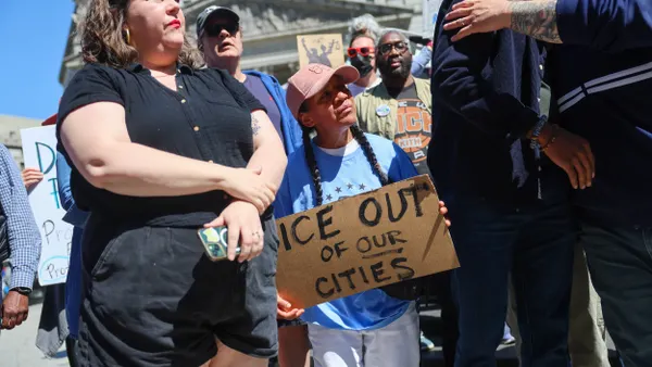 A crowd of protesters with signs. Sign reads "ICE out of our cities."