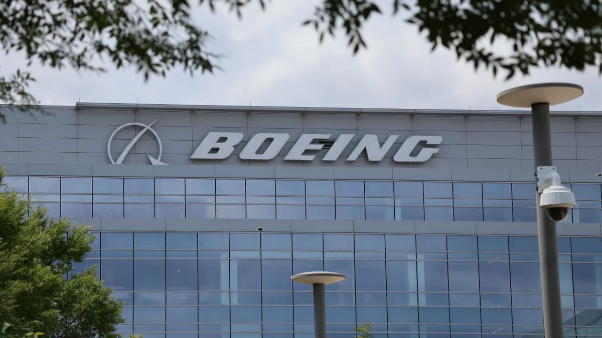 A gray building with glass windows and the white Boeing logo on its top front.